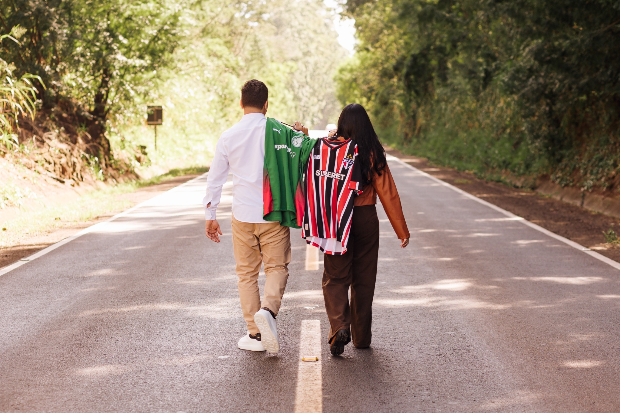 Dionathan e Giovanna caminhando juntos com camisas de futebol