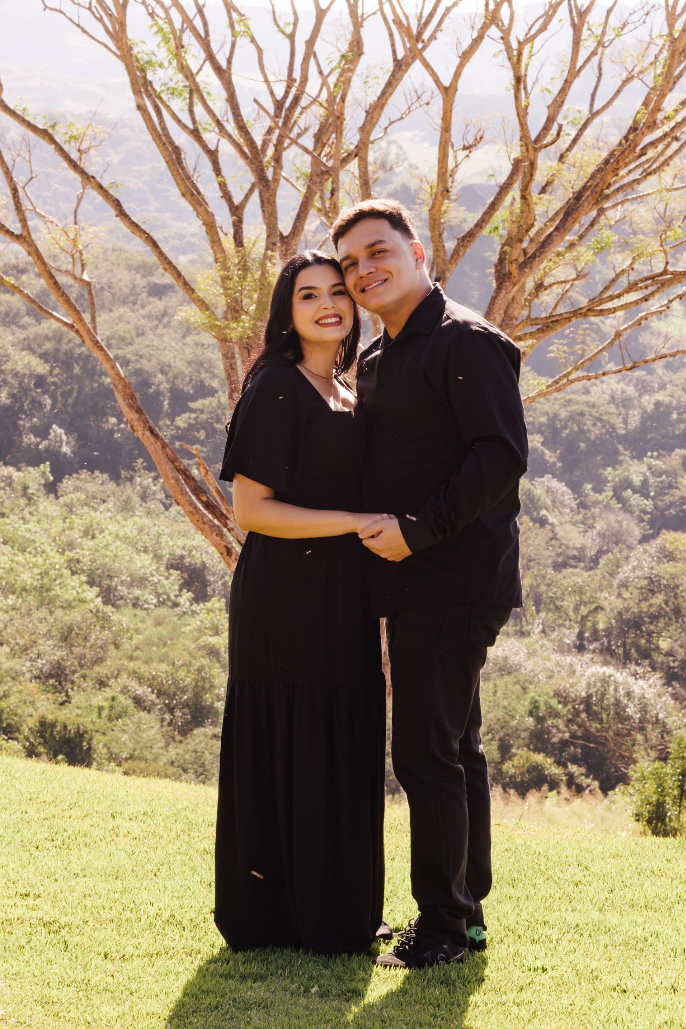 Dionathan e Giovanna de mãos dadas em frente às árvores